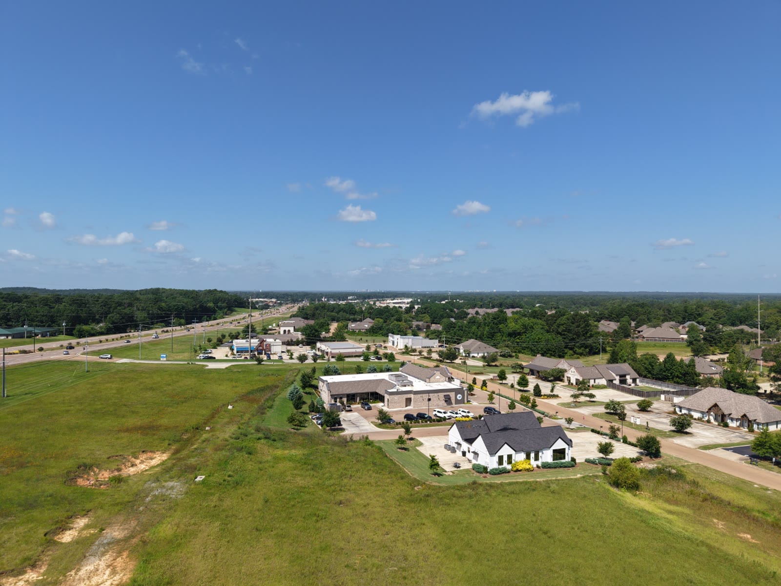 Aerial view of a residential subdivision with new homes, driveways, and landscaped lots in Central Mississippi